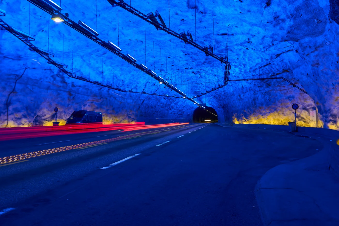 Blaues Licht erhellt die Felsenmauern im Inneren des Laerdalstunnel, der hier eine breite Ausbuchtung aufweist.