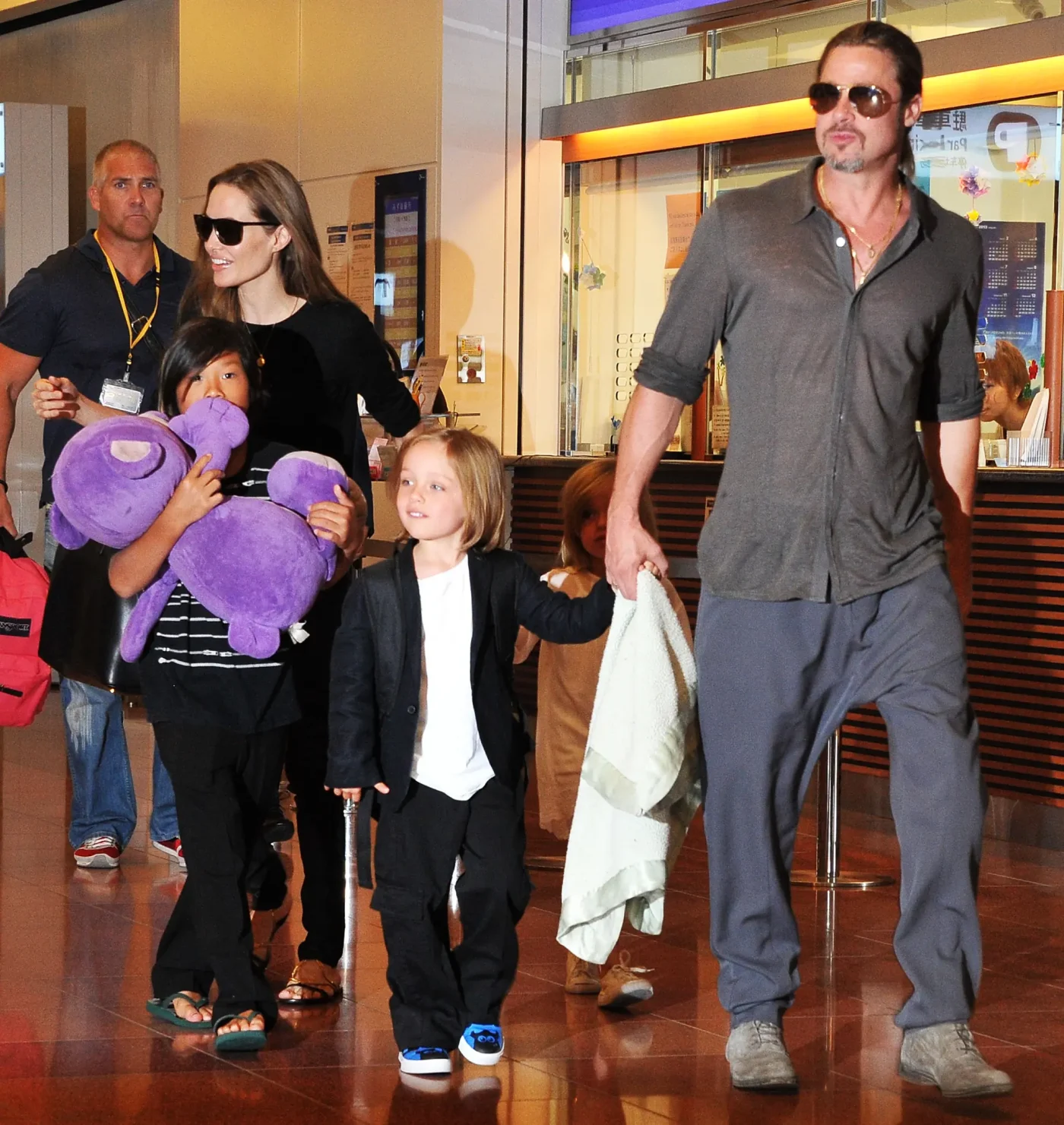 Brad Pitt, Angelina Jolie, and their children Pax, Knox, and Vivienne walking through an airport.