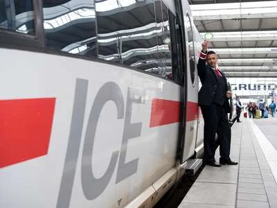 Ein abfahrtbereiter ICE am Bahnsteig – der Zugchef hebt die Kelle.