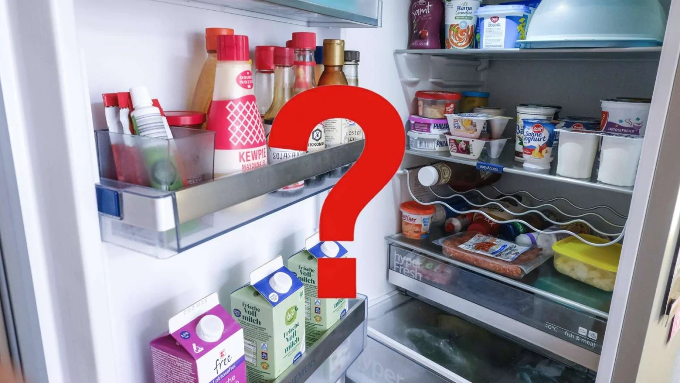 Ein rotes Fragezeichen vor einem offenen Kühlschrank.