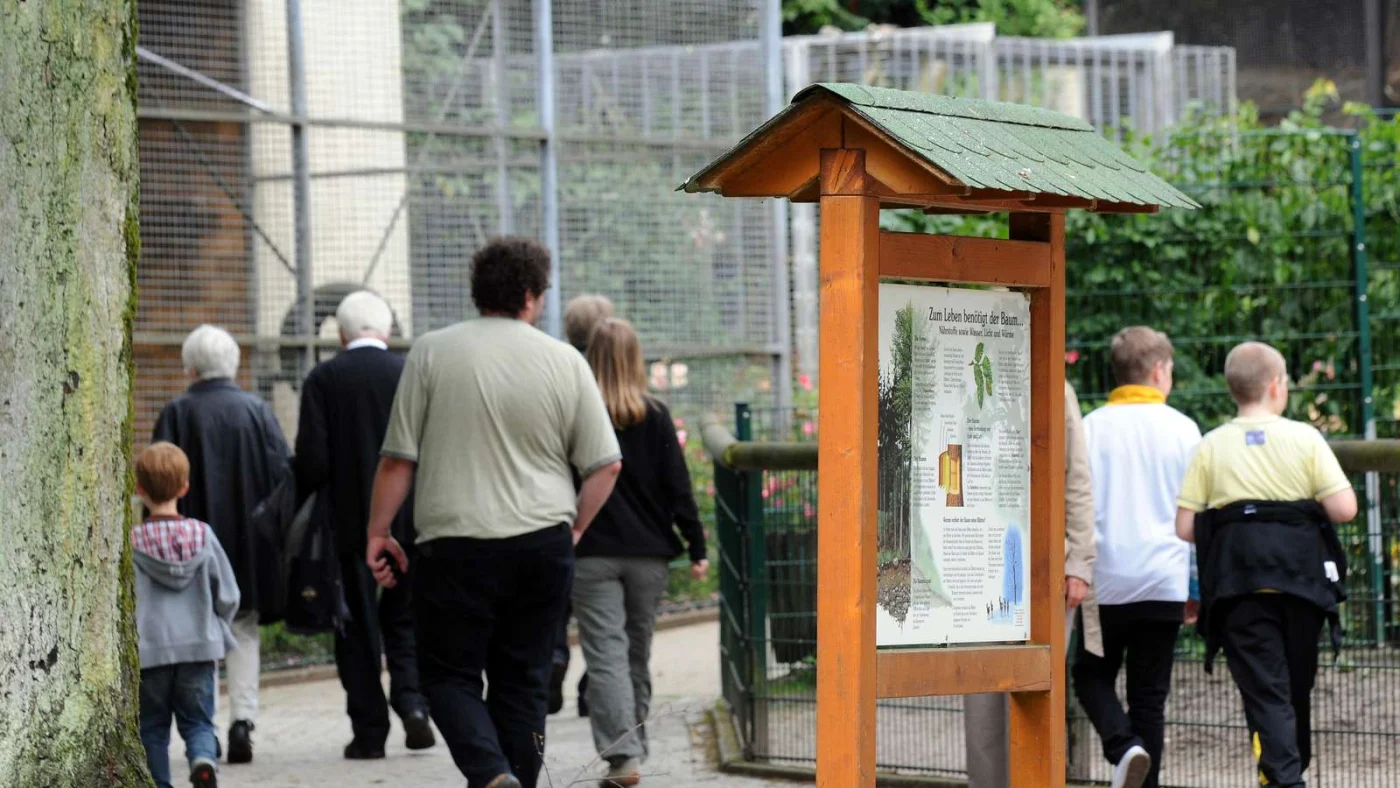 Ein Schild und Besucher im Tierpark Recklinghausen