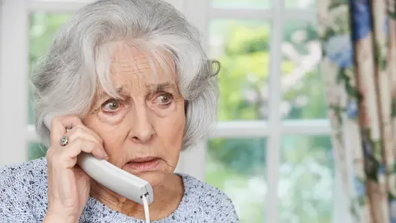 Eine besorgte ältere Frau am Telefon.