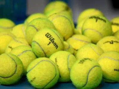 Mehrere Tennisbälle auf dem Boden.