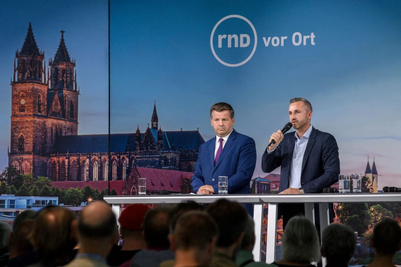 Sven Schulze (l, CDU), Ministerpräsident von Sachsen-Anhalt und Ulrich Siegmund (AfD) stehen in der Hyparschale in Magdeburg auf der Bühne.