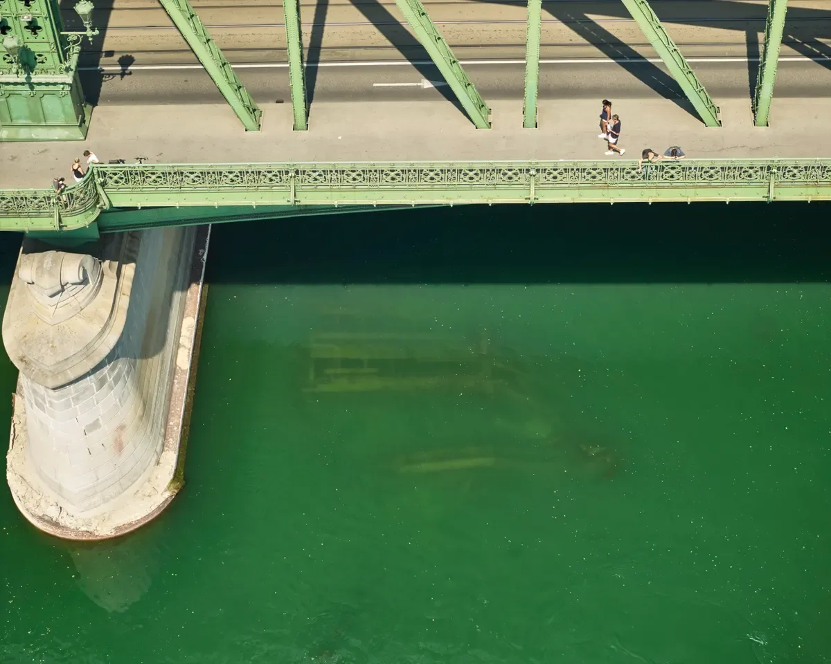 The remains of a bridge submerged in shallow water