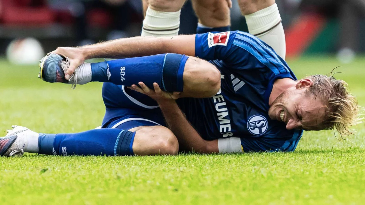 Timo Becker verletzt im Schalke-Trikot am Boden.