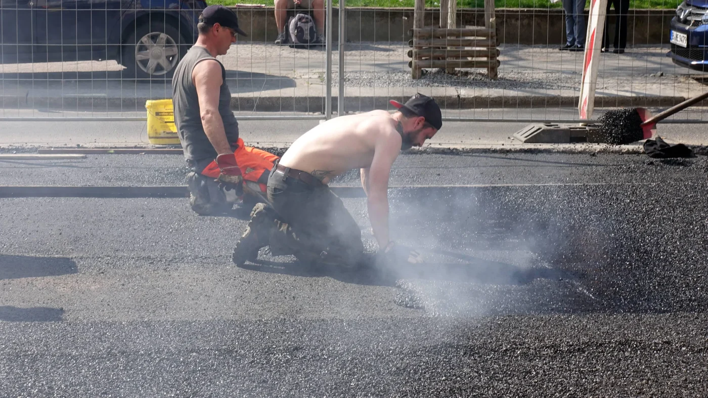 11.04.2018, Berlin, GER - Bauarbeiter teeren eine Strasse. (30-40 Jahre, Alltag, Arbeit, arbeiten, Asphalt, Asphaltieren, asphaltieren, Asphaltierungsarbeiten, aussen, Aussenaufnahme, Bauarbeiten, Bauarbeiter, Baubranche, bauen, Baustelle, Bauwesen, Bauwirtschaft, Berlin, Beruf, Berufsleben, Daempfe, deutsch, Deutschland, erneuern, Erneuerung, Europa, europaeisch, Fruehjahr, Fruehling, Gesellschaft, gesundheitsschaedlich, glaetten, heiss, Hitze, Jahreszeit, Job, Kaukasier, kaukasisch, Maenner, Menschen, Per