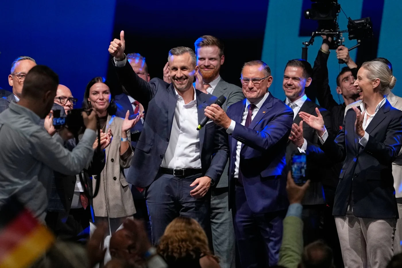 AfD-Spitzenkandidat Ulrich Siegmund zeigt Daumen hoch neben Parteichefs Tino Chrupalla und Alice Weidel bei der Wahlparty in Magdeburg.