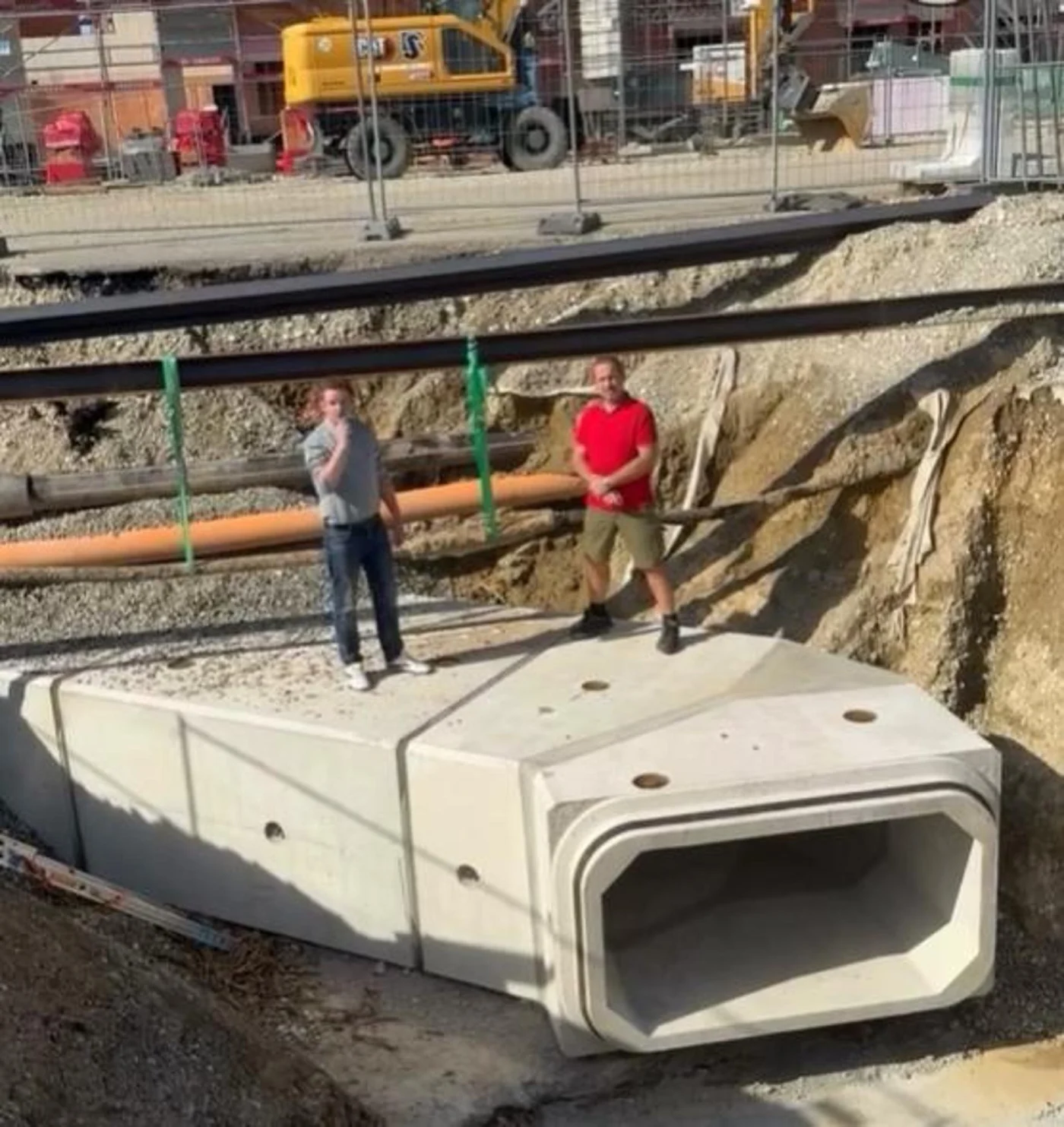 Bürgermeister Andreas Wagner (l.) hatte Matthias Zimmerer zu seinem wöchentliche Videobericht eingeladen, um sein Wissen über das Erdkabel weiterzugeben. Das Kabel selbst hängt im Hintergrund an grünen Spanngurten.