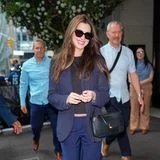 Business Casual? Geht als Schwangere natürlich auch! In einem monochromen Ensemble in Dunkelblautönen, das Anne Hathaway mit schwarzen Basics wie der Cara Bag von Ferragamo aus der AW 26 Kollektion und Netzballerinas von Alaia kombiniert, lässt es die bald Dreifach-Mama entspannt angehen.