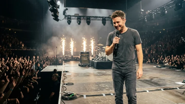 Wincent Weiss singt leidenschaftlich mit Mikrofon auf einer Konzertbühne vor jubelndem Publikum