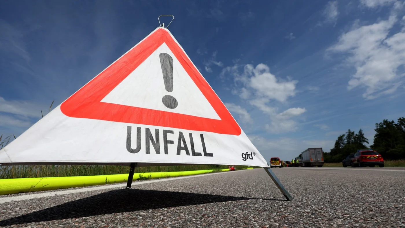 Ein Warndreieck mit der Aufschrift "Unfall" steht auf einer Autobahn (Symbolbild).