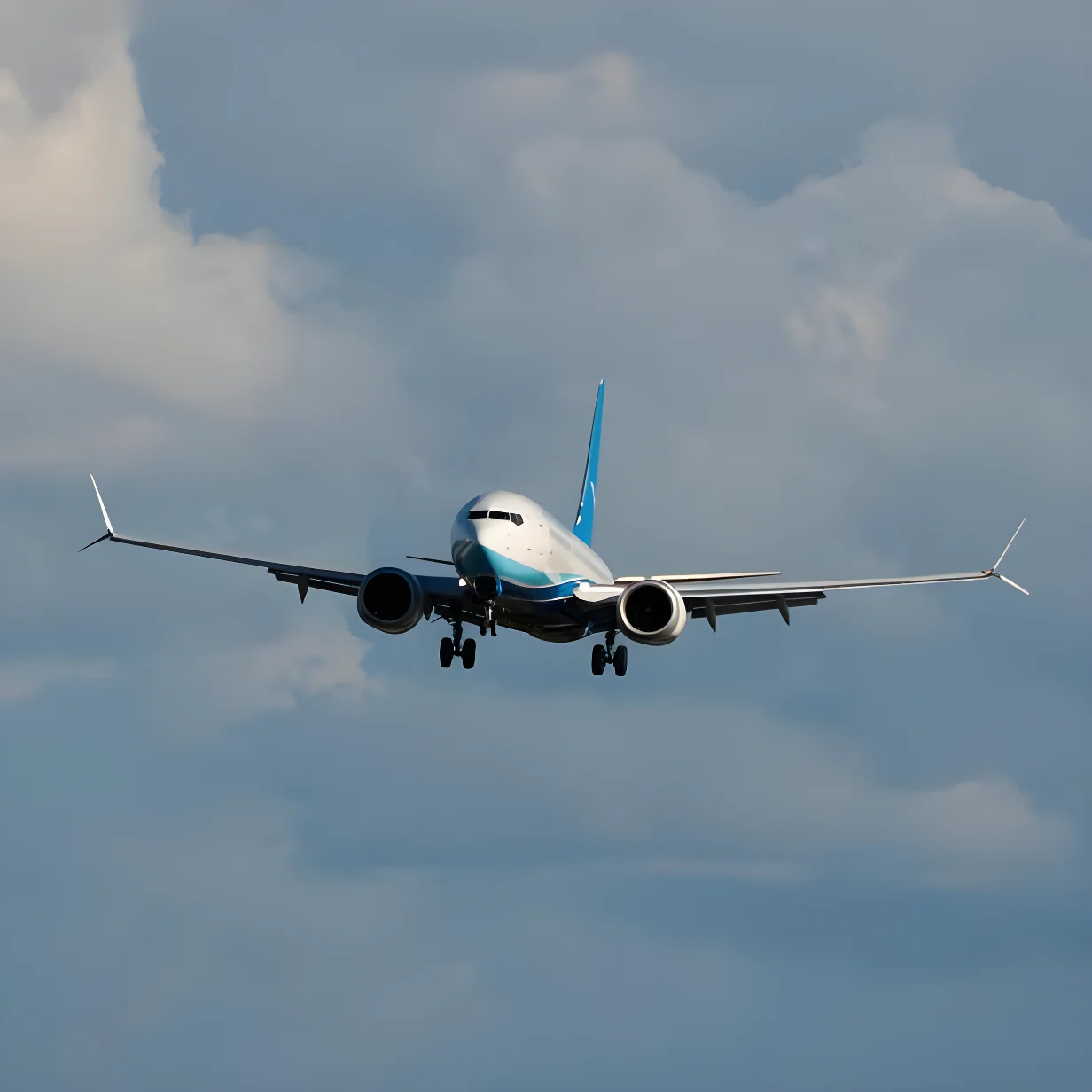 Flugzeug im Landeanflug vor wolkigem Himmel.