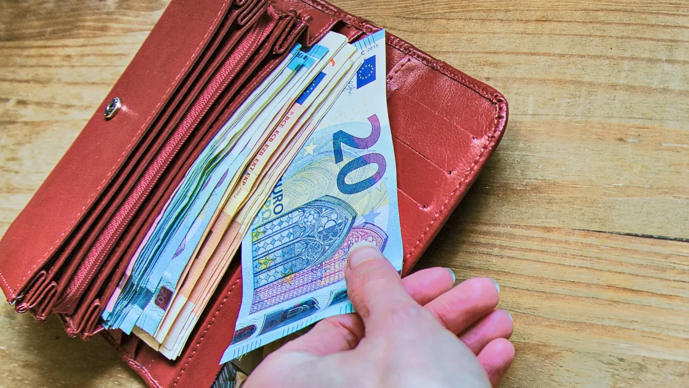 Geld wird aus dem Geldbeutel genommen.