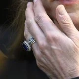 In der Mitte trägt Catherine ihren berühmten Verlobungsring mit dem großen Saphir, dazu den goldenen Ehering sowie drei Eternity-Rings. Der auffälligste davon ist der mit Diamanten und Saphiren, der perfekt zum Verlobungsring passt. Es wird gemunkelt, er sei ein Geschenk von Prinz William zum Abschluss der Chemotherapie, einige Male war er schon an Kates Hand zu bewundern. Ein etwas kleinerer Pavé-Ring mit Diamanten ist ebenfalls ein neueres Stück in ihrem Schmuckkästchen. Ganz außen liegt noch ein Ewigkeitsring, ein älteres Stück von der Juwelierin Annoushka, er soll ein Geschenk von William zu Georges Geburt 2013 gewesen sein. Alle fünf Ringe symbolisieren die Liebe, zu William, ihren Kindern und der ganzen Familie.