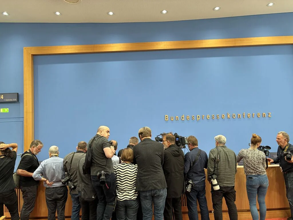 Journalisten und Fotografen drängen sich an einem Podium bei der Bundespressekonferenz in Berlin.