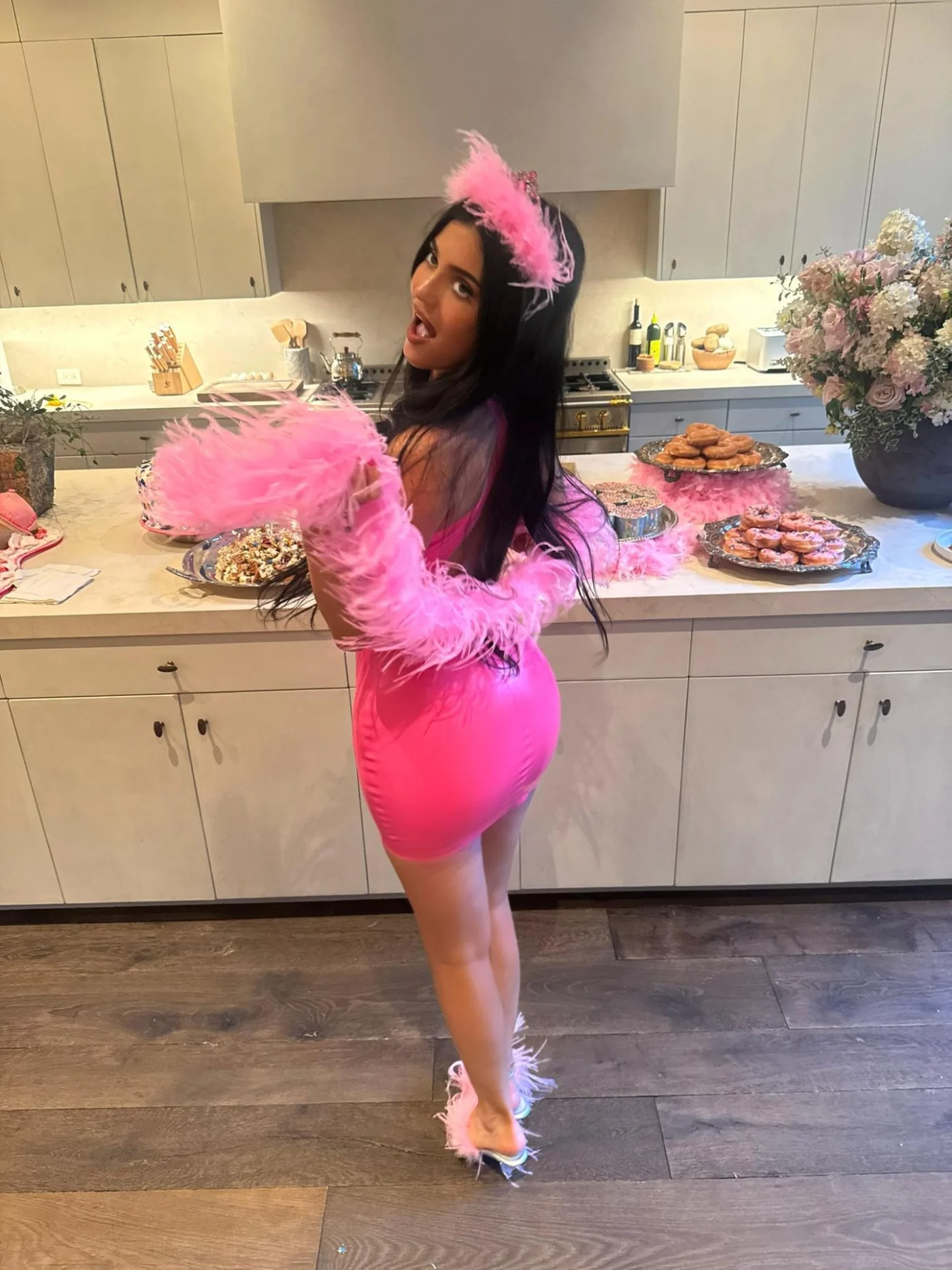Kylie Jenner lässt es anlässlich ihres 29. Geburtstags bereits am Abend vorher ordentlich krachen. Bei ihrer "Princess-Kitty"-Party posiert die Unternehmerin vor einer mit Geburtstagsleckereien gefüllten Kücheninsel in einem pinken Latex-Minikleid. Dazu trägt sie eine Federboa, eine passende Federkrone und mit Federn besetzte Heels, natürlich ebenfalls in Rosa.