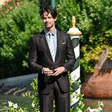 Patrick Schwarzenegger erreicht den Bootssteg am Hotel in einem dunklen Nadelstreifen-Anzug, witzig kombiniert mit einem Streifenhemd mit Leo-Print-Kragen und gestreifter Krawatte.