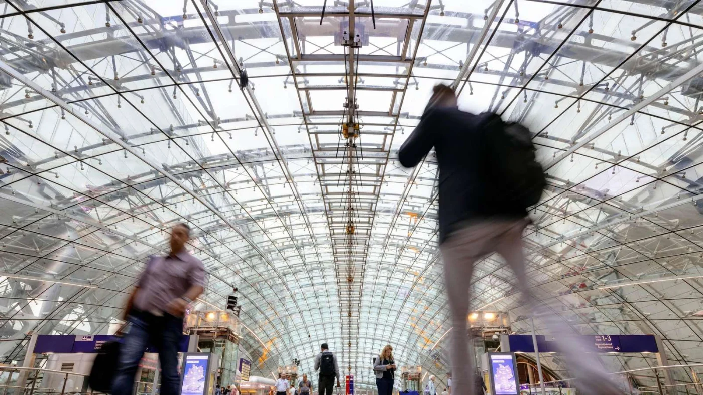 Reisende laufen durch den Fernbahnhof am Flughafen Frankfurt.