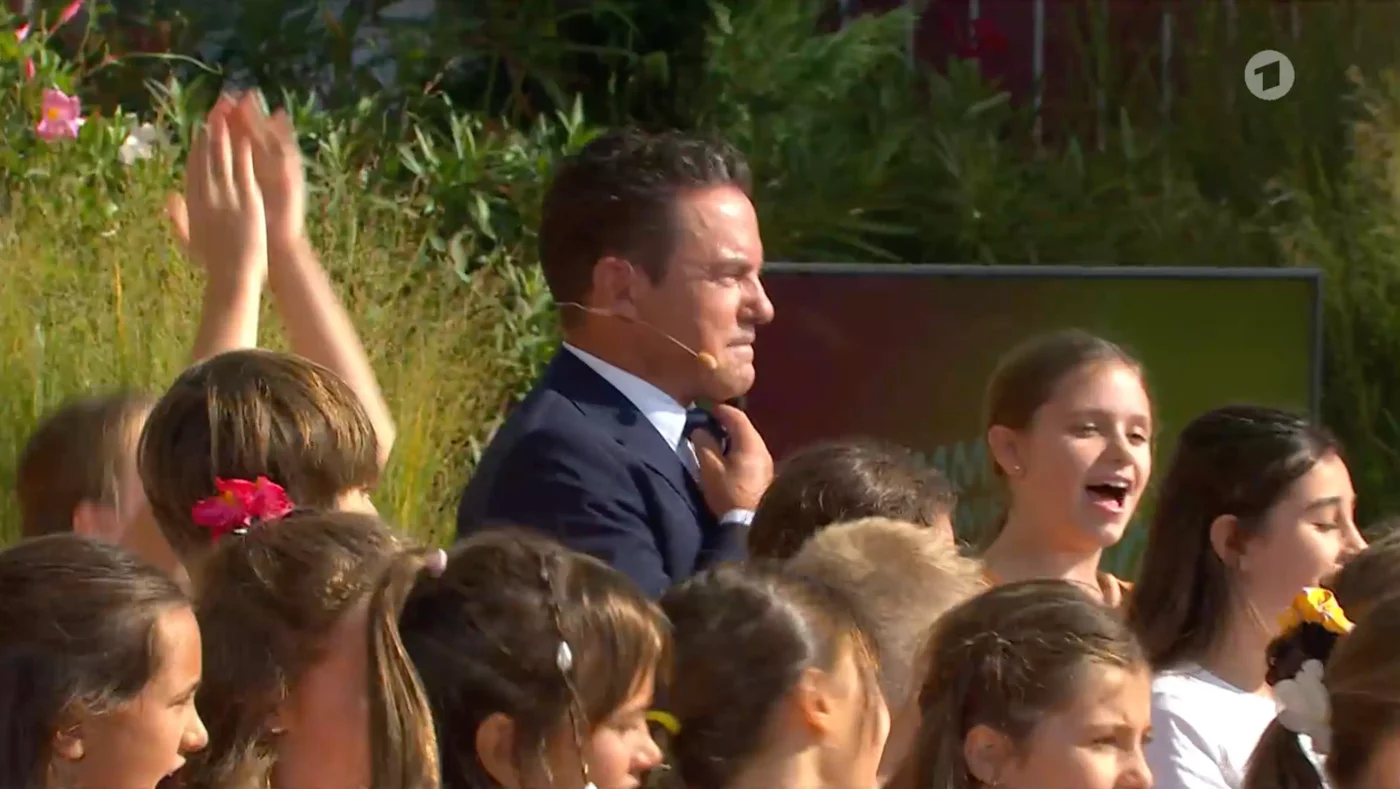 Stefan Mross, sichtlich gerührt, mitten im Kinderchor.