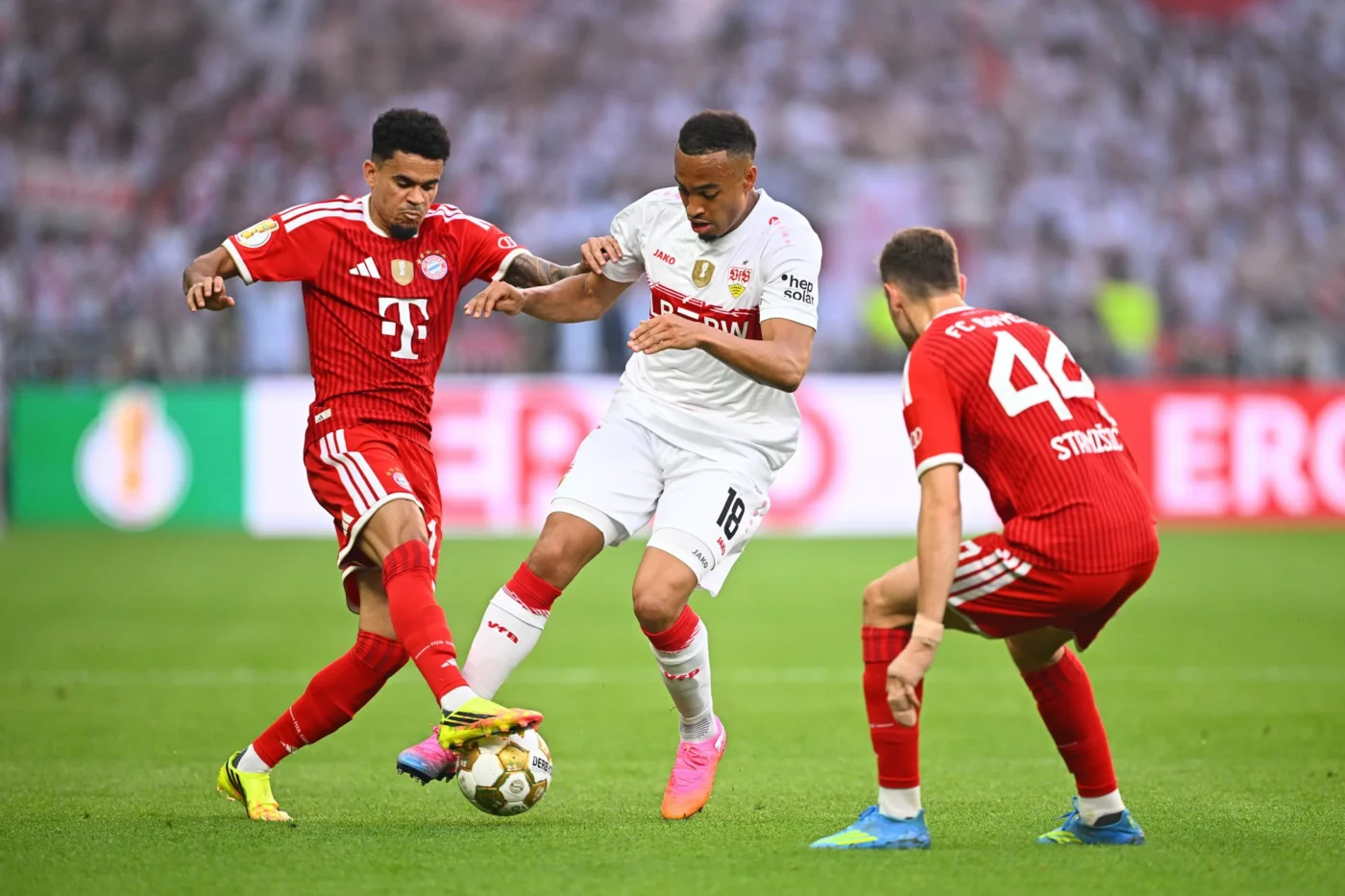 Stuttgarts Jamie Leweling (M.) gegen die Bayern Luis Diaz (l.) und Josip Stanisic im DFB-Pokalfinale 2026