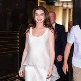 Unter diesem cremefarbenen Satinkleid versteckt sich ihr wachsender Babybauch! Für ihren Auftritt bei der Late-Night-Show in New York strahlt Anne Hathaway in einem Custom-Piece von GapStudio des Designers Zac Posen. Die schräg geschnittene Silhouette umspielt ihre Körpermitte elegant, während das transparente Tunikatop mit asymmetrischem Saum dem minimalistischen Look Dynamik verleiht. Metallische Peep-Toe-Heels und dezenter Schmuck runden das Outfit stilvoll ab. Eines trägt die Schauspielerin ohnehin am schönsten: ihr strahlendes Lächeln.