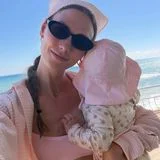 Wie die Mama, so die Tochter: Karlie Kloss setzt für ihren Beach-Look auf zartes Ballerina-Rosa und trägt Bikini, luftiges Hemd und Bandana Ton in Ton. Die kleine Rae Florence macht den Partnerlook perfekt – mit rosafarbenem Sonnenhut und einem Badeanzug voller kleiner Pfirsiche. Ein Mini-Me-Moment in Rosa, der kaum süßer sein könnte.