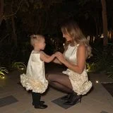Zu so einer stylischen Mutter würden wir auch bewundernd aufschauen! Gioia Götze feiert bereits ihr zweites Silvester in Dubai und darf für diesen besonderen Anlass exakt das Outfit tragen, in dem auch Mama Annkathrin strahlt. Beide bezaubern in einem kurzen, ärmellosen Satinkleid mit ausladenden Rüschen am Saum. Ihre cremefarbenen Dresses von Onrose Studio kombinierten die Götze-Ladys mit altersentsprechenden schwarzen Schuhen, und selbst die schwarze Strumpfhose teilen sich die Frau von Fußballweltmeister Mario Götze und ihr Mini-Me. Zuckersüß!