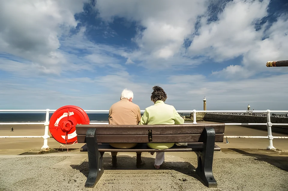 Zwewi ältere Menschen sitzen auf einer Bank in der Nähe eines Strandes